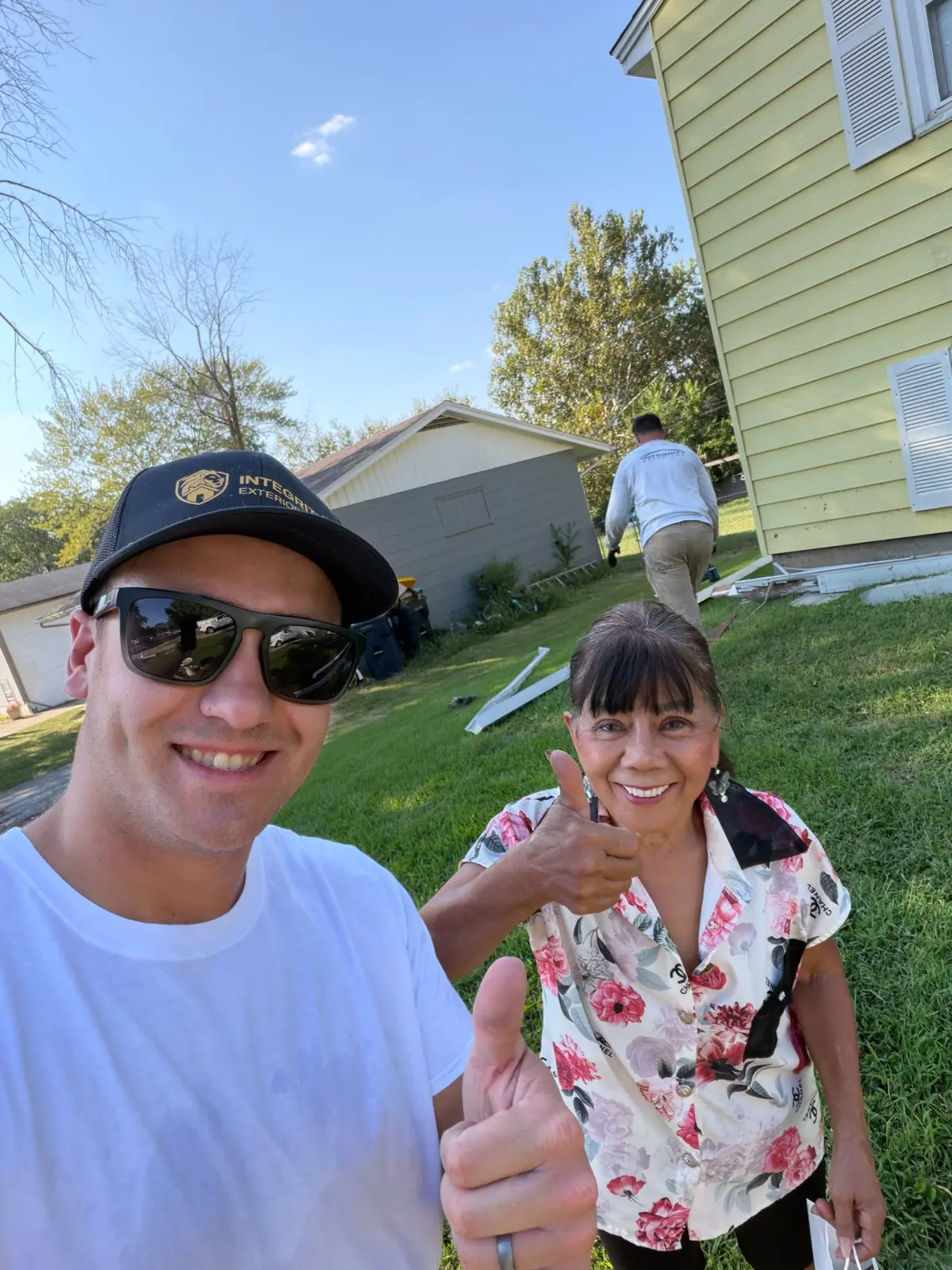 Integrity Exteriors team member with a happy customer at a Kansas City gutter project