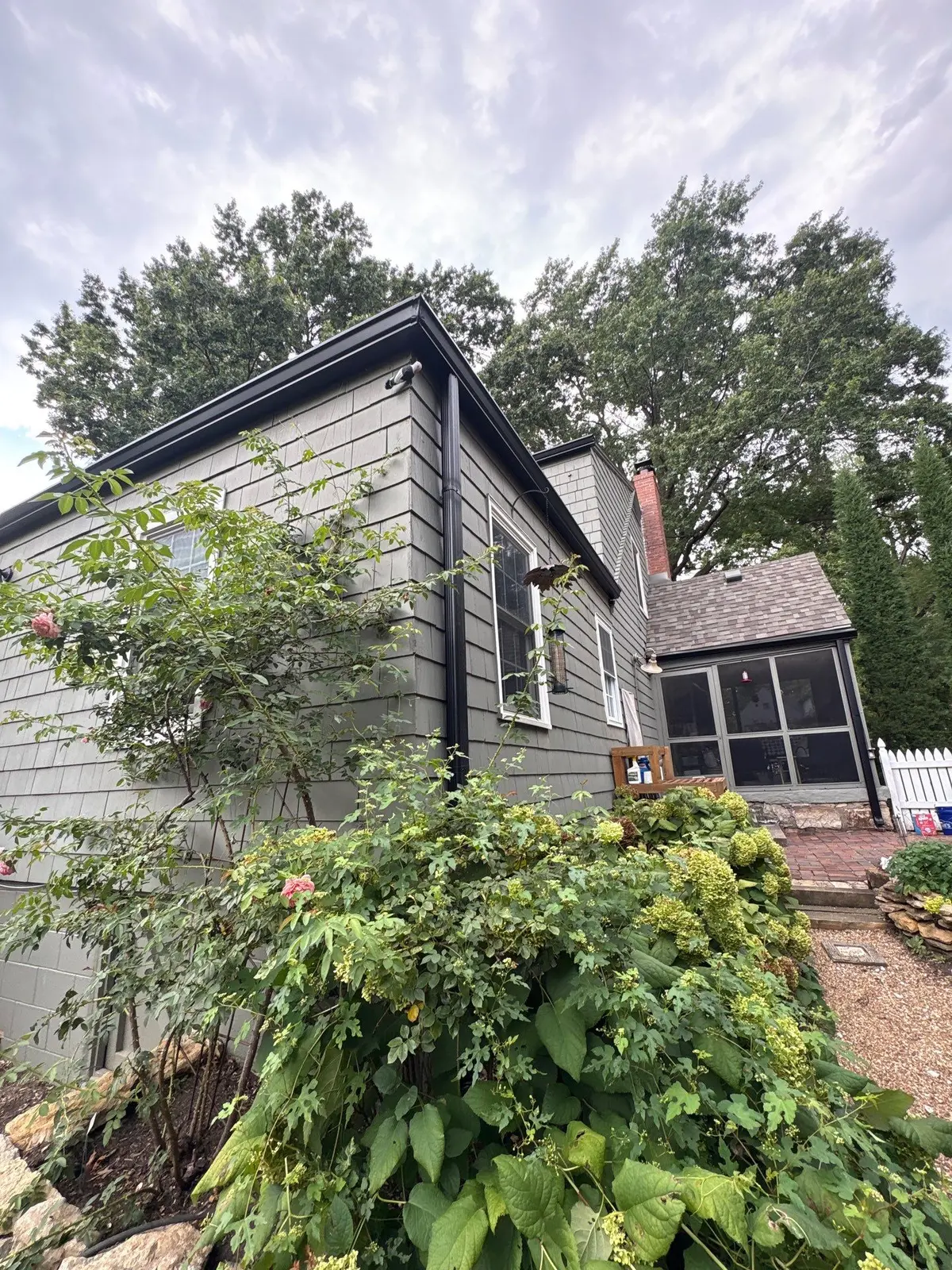 Black gutters and downspouts installed around a home