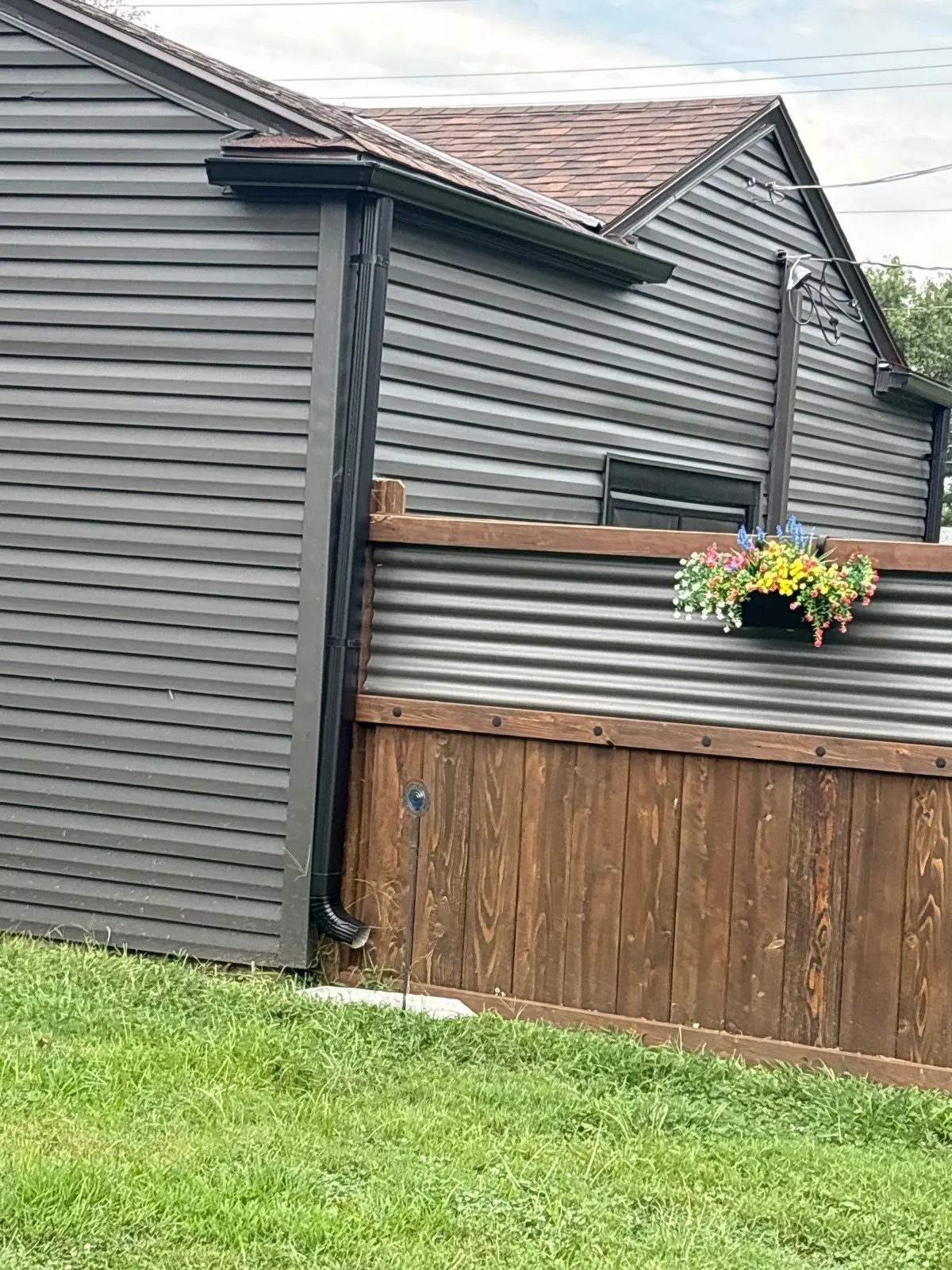 Downspout routed beside a residential deck