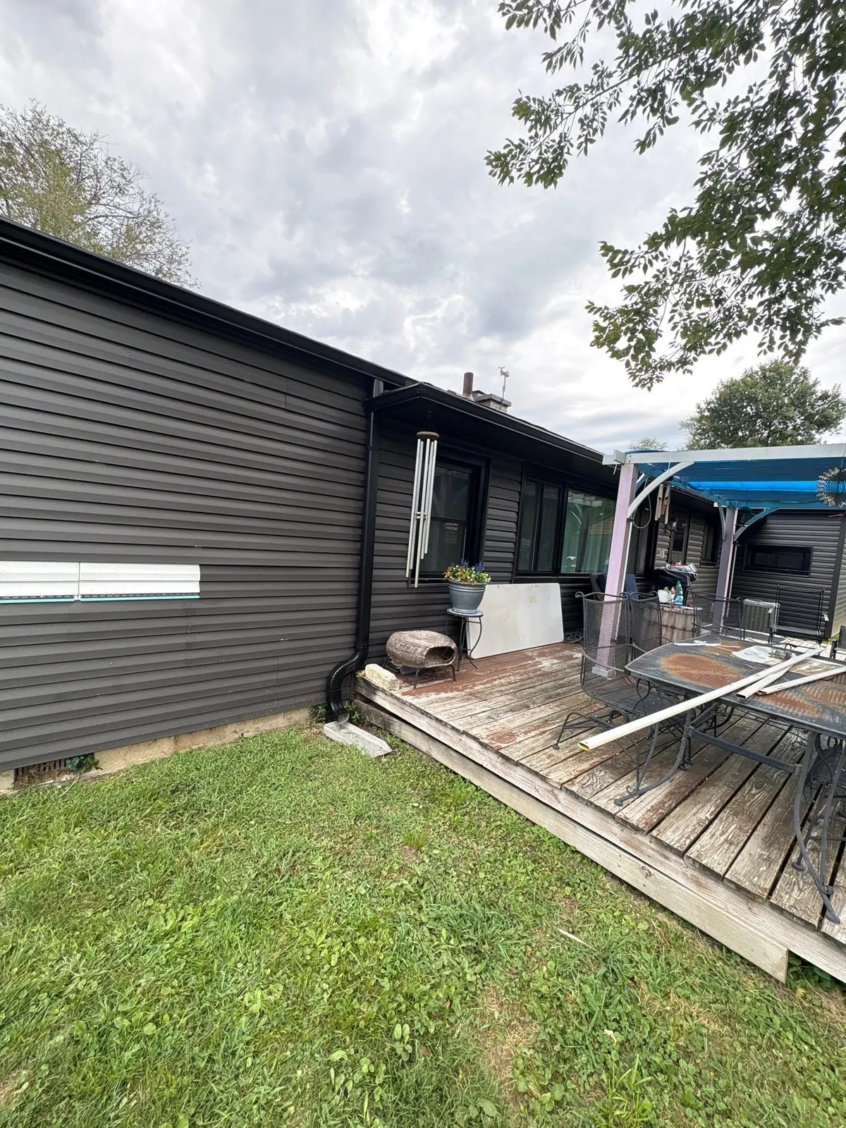 Black seamless gutters installed around a patio