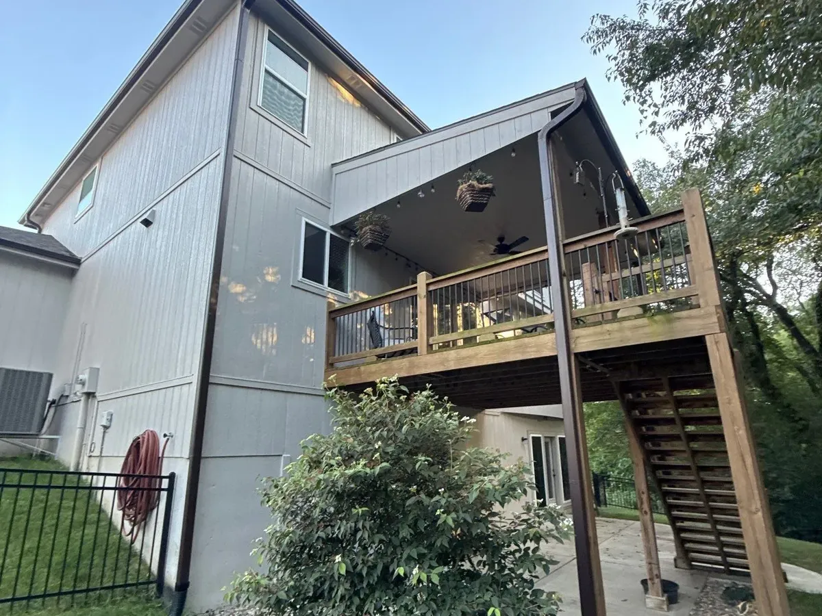 Oversized 3x4 downspouts beside a rear deck in Parkville, MO