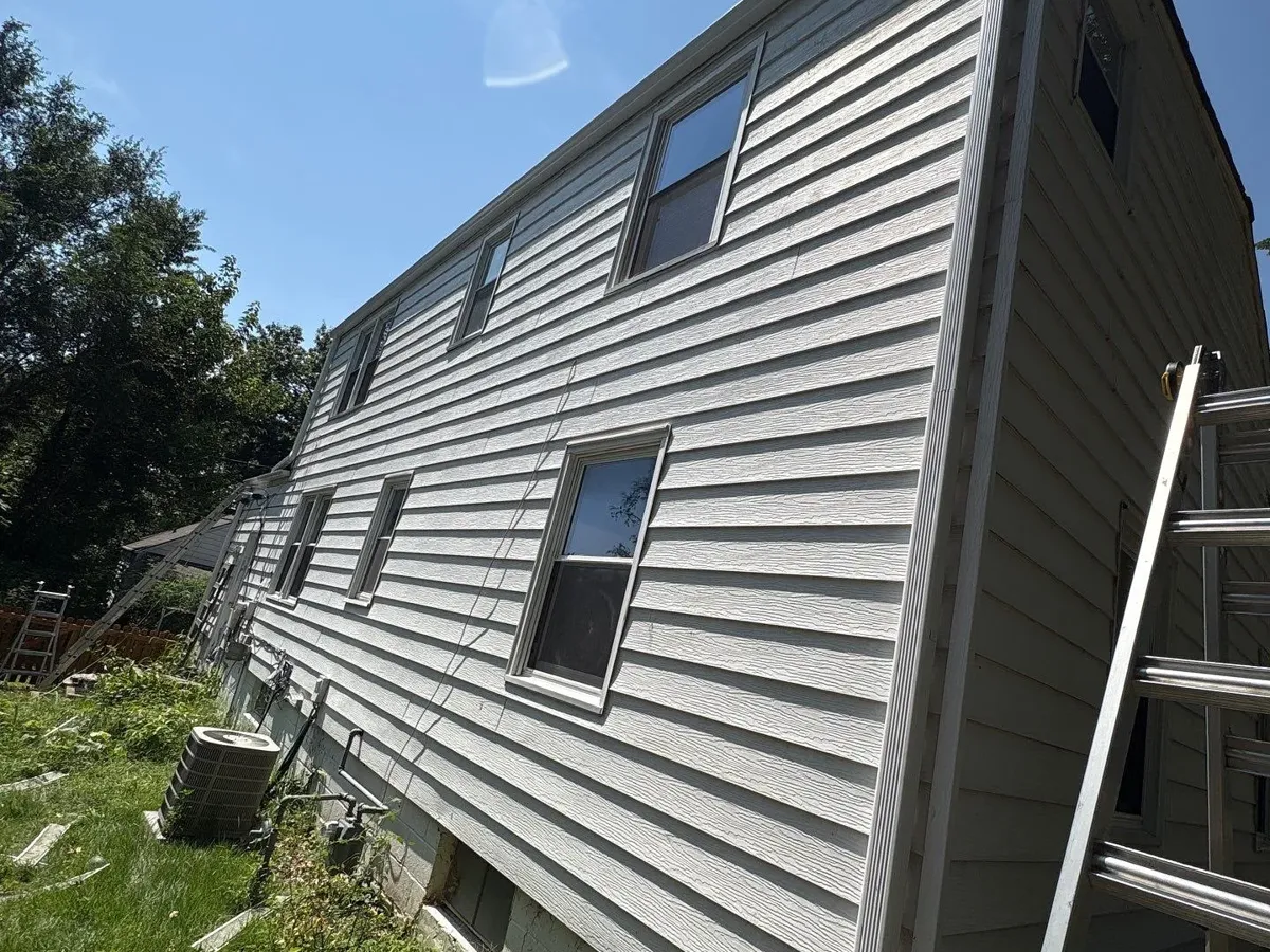 White seamless gutters and a 3x4 downspout on a story-and-a-half home in Roeland Park, KS